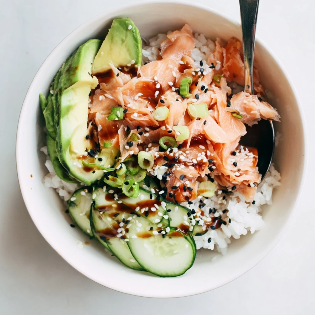 Delicious leftover salmon and rice bowl topped with fresh avocado and cucumber.  