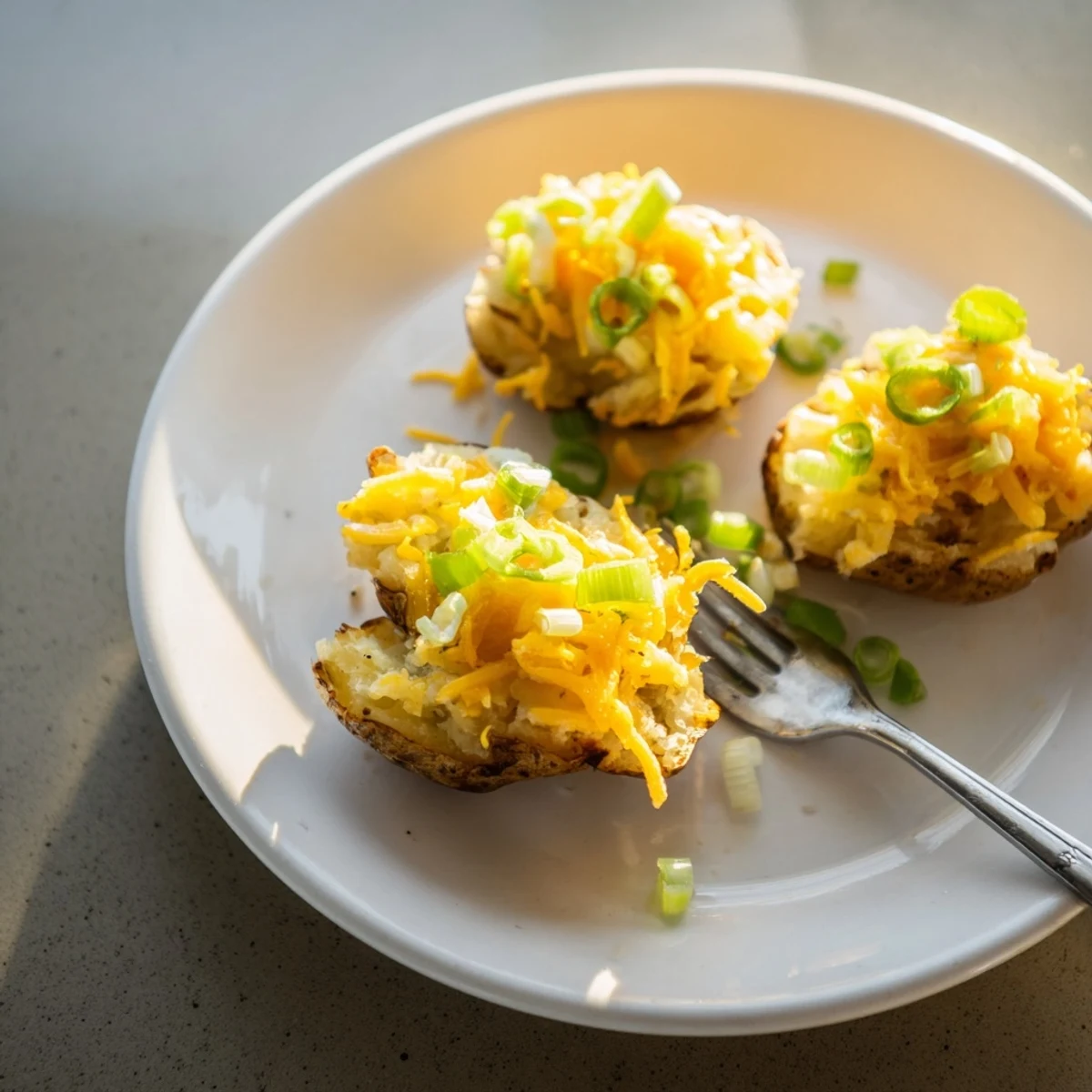 Crispy smashed green onion potato bombs topped with melted cheddar and fresh herbs.  