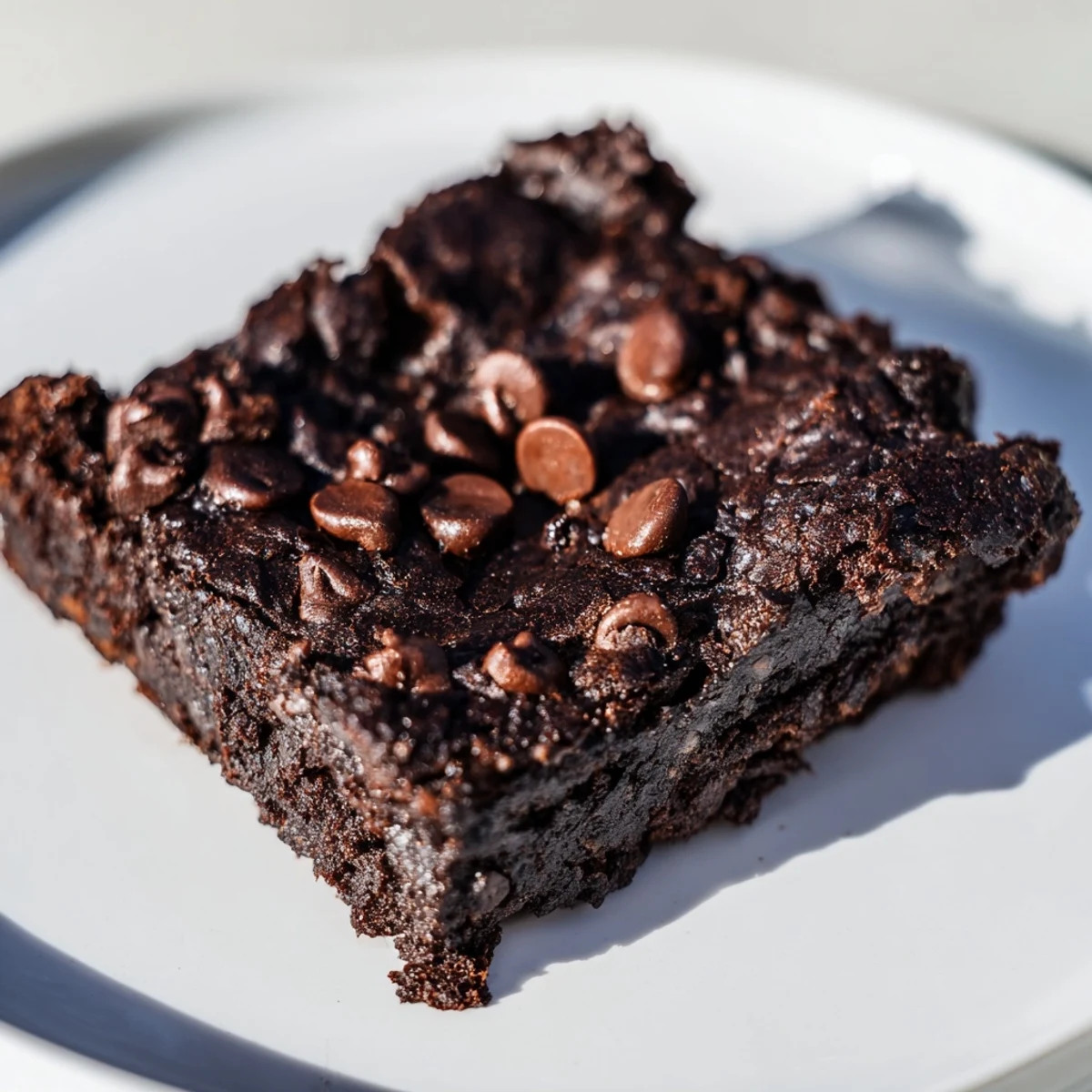 Moist, fudgy Black Bean Brownies with chocolate chips, ready to slice and enjoy as a treat.