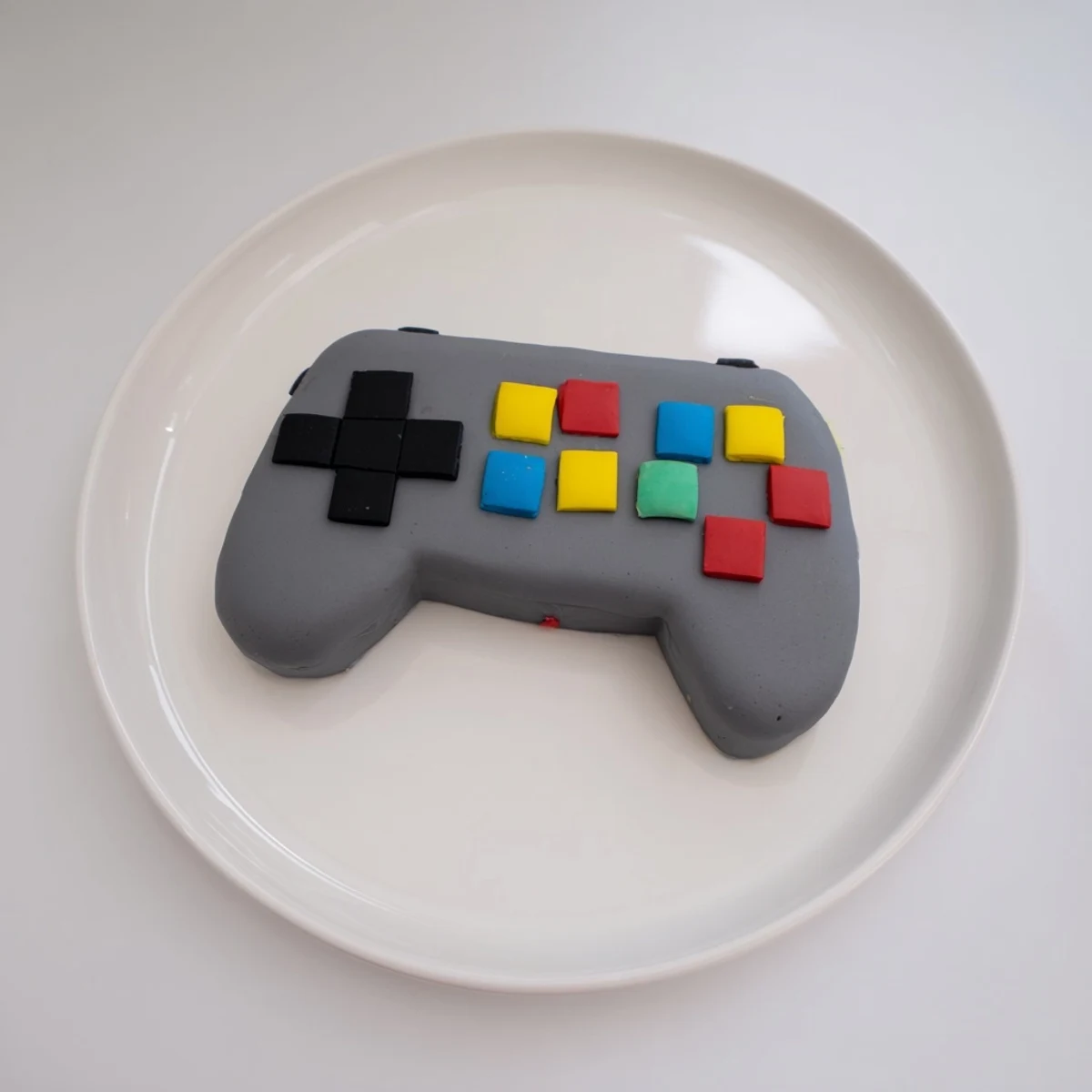 Vibrant fondant turns this pixel video game controller cake into a fun, edible game day centerpiece.