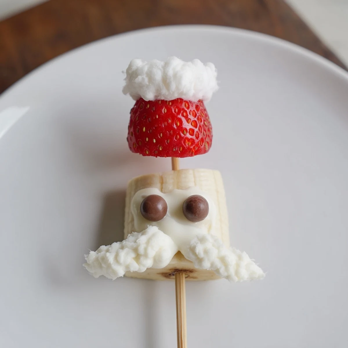 Banana Strawberry Santa Skewers: a close-up of festive fruit skewers with banana, strawberry, and chocolate chip details.