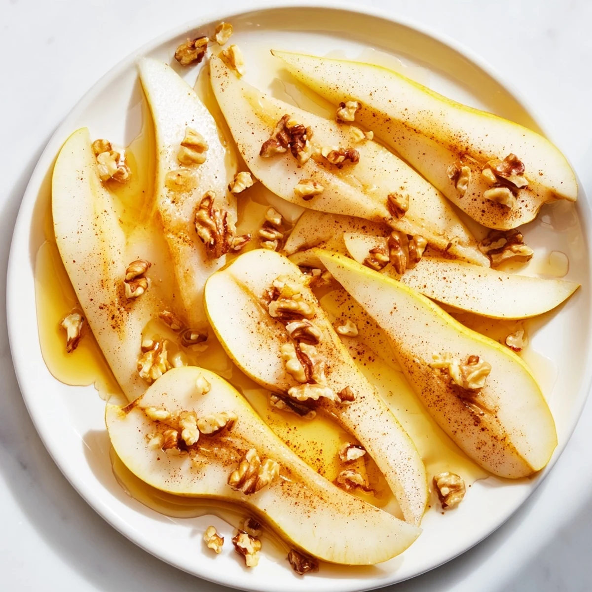 Fresh pear slices with golden honey drizzle, a simple and elegant dessert.