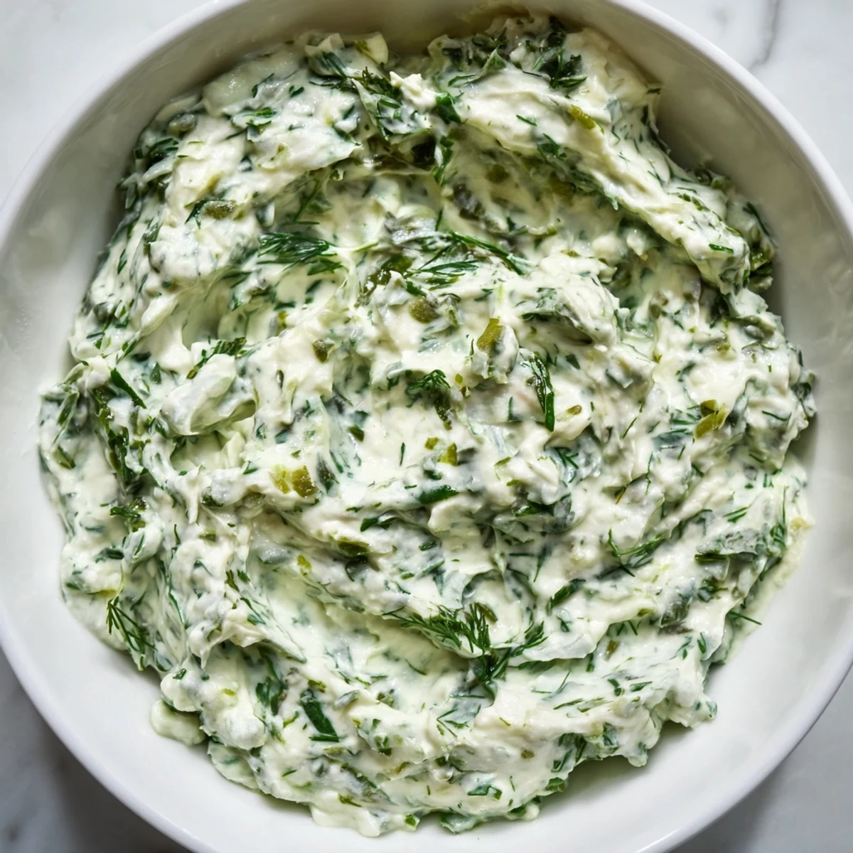 A close-up shot of homemade Green Goddess Dip, wonderfully smooth and ready to serve.
