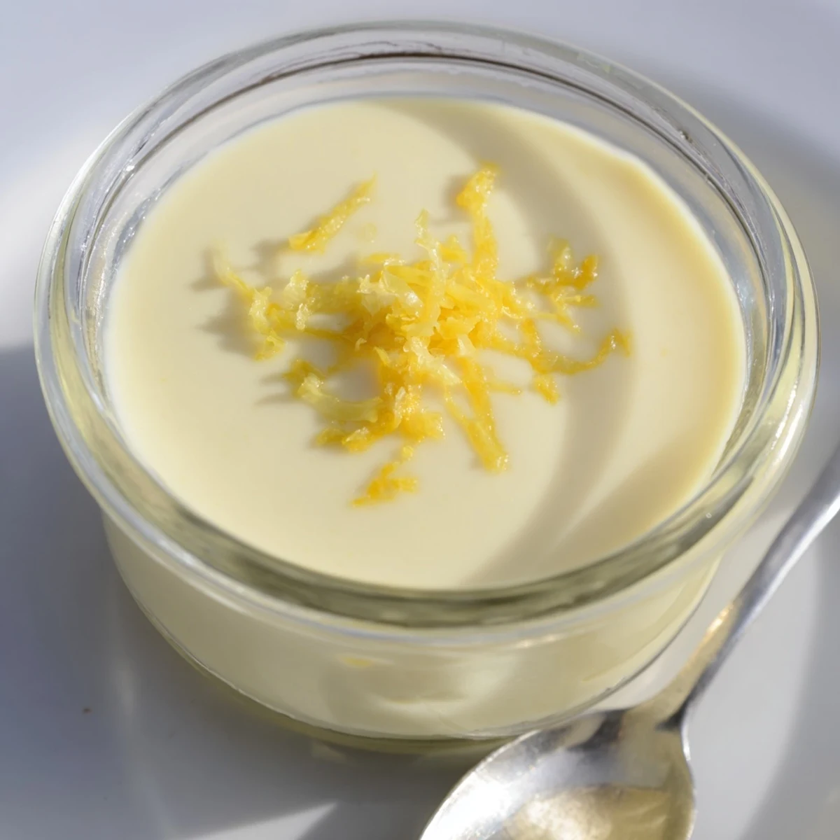 The finished 3-Ingredient Lemon Posset is creamy white, garnished and set delightfully in glass dishes.