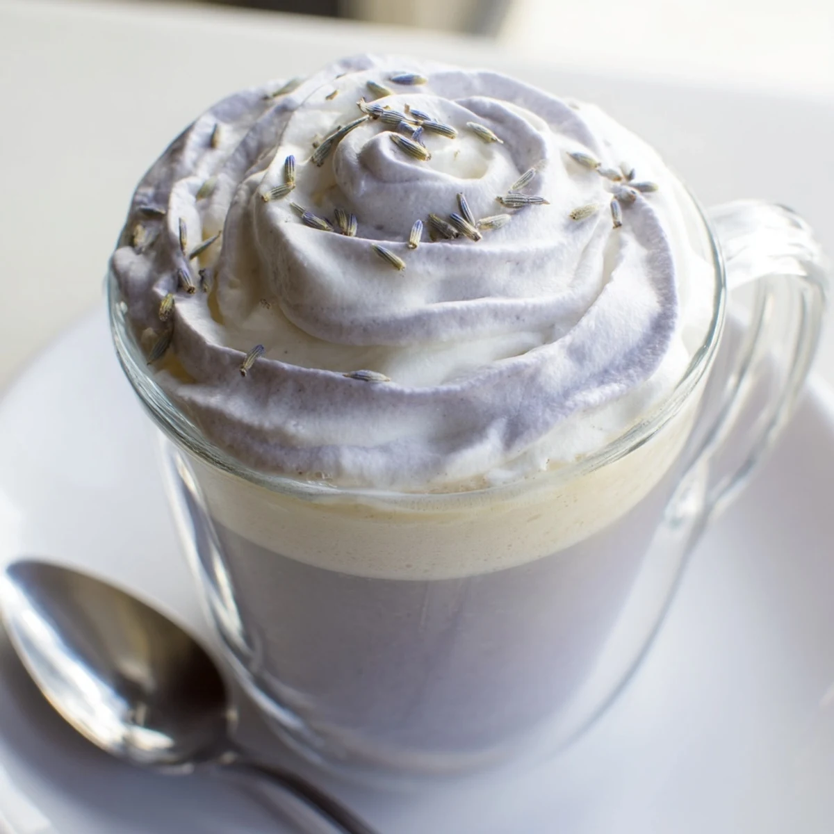 Steaming Whipped Lavender Latte topped with fluffy foam and a delicate lavender sprig, ready to enjoy.