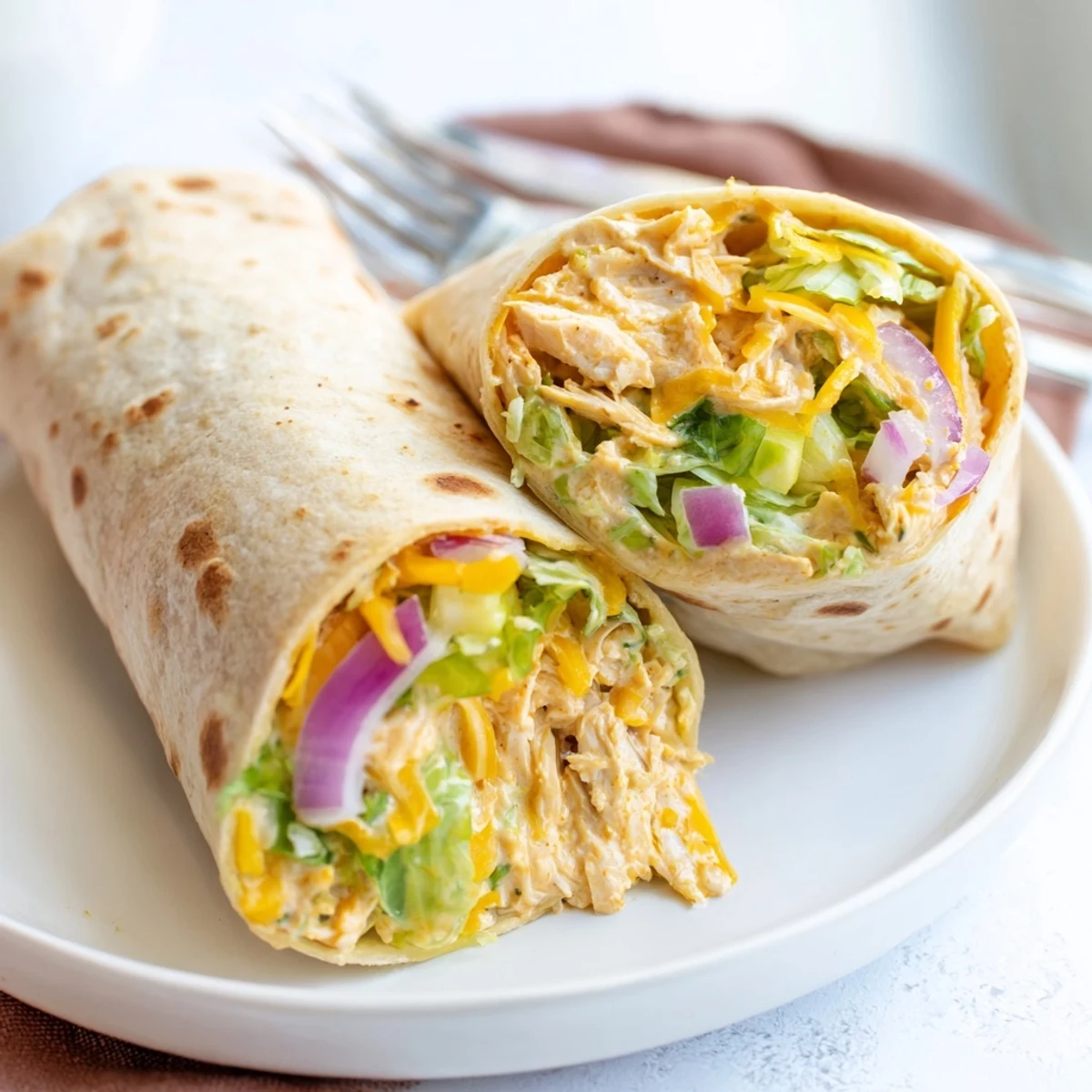 Perfectly rolled wrap ready to serve with extra ranch drizzle and buffalo sauce.