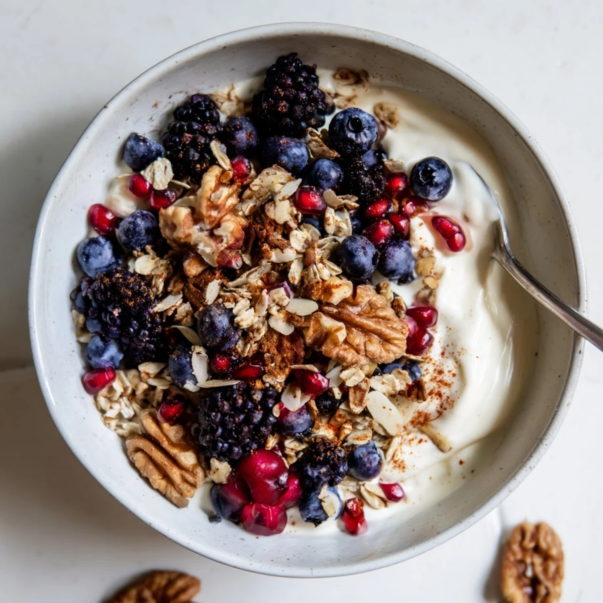 A vibrant bowl of Yogurt Bowl with Winter Berries and Spiced Crunch, featuring creamy yogurt topped with tart cranberries and toasted oats.  