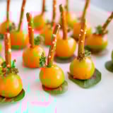 A vibrant Pumpkin Patch Grid appetizer: tiny cheese pumpkins sit in a green field, ready to eat.