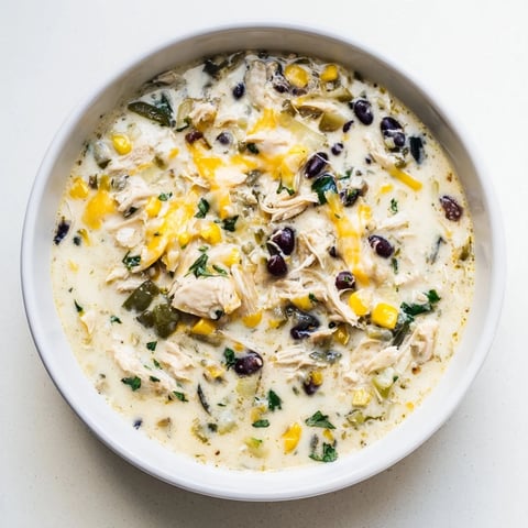A steaming bowl of Chicken Poblano Soup, garnished with fresh cilantro, ready to be enjoyed.