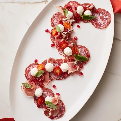 Festive holiday charcuterie board, the Candy Cane Zigzag, artfully arranged with salami and mozzarella.