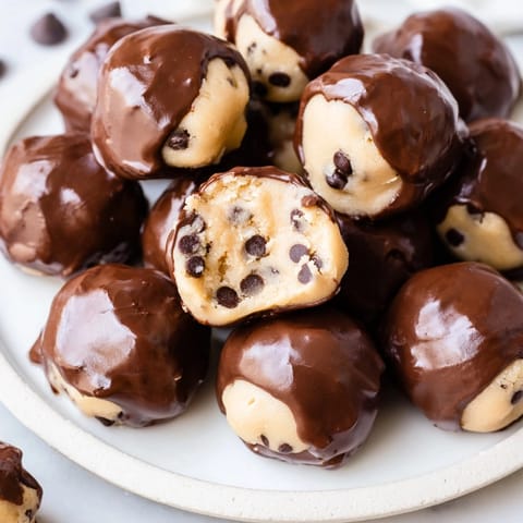 Delectable no-bake Cookie Dough Bites glistening with smooth semi-sweet chocolate, chilled to perfection.