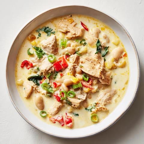 A warm bowl of Creamy White Chicken Chili with visible chunks of chicken and creamy base.