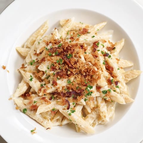 A bubbly, sheet pan mac and cheese, featuring a golden crust and savory bacon topping.