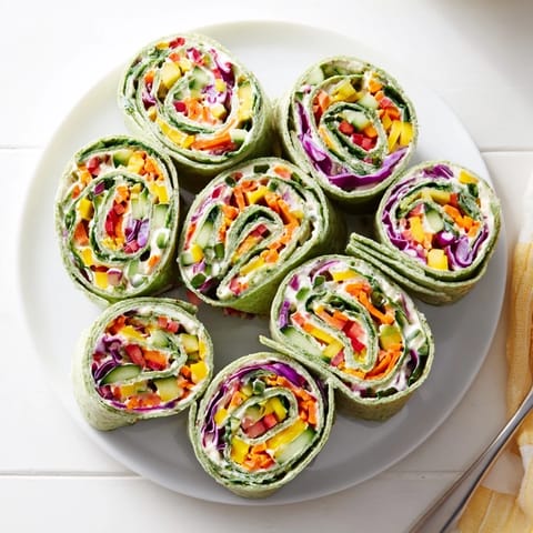 Brightly arranged Rainbow Veggie Christmas Lights Wrap Pinwheels, ready to serve as a tasty, vegetarian appetizer.