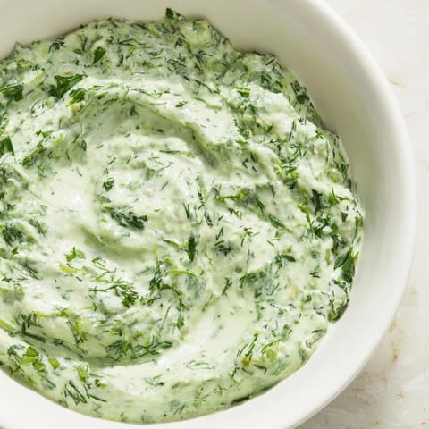 Bright green Green Goddess Dip with visible flecks of herbs, ready for dipping and spreading.