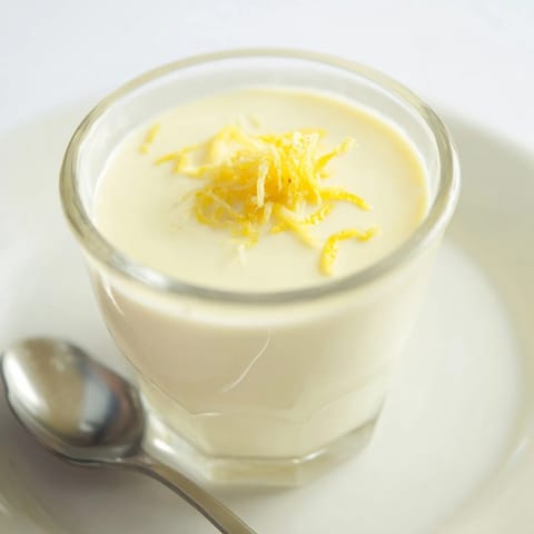 This photo features the elegant, softly set 3-Ingredient Lemon Posset, ready for a delectable bite.