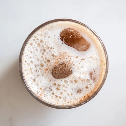 Cool, refreshing Iced Chai Tea with cold foam, perfect for a sunny afternoon, pictured with cinnamon garnish.