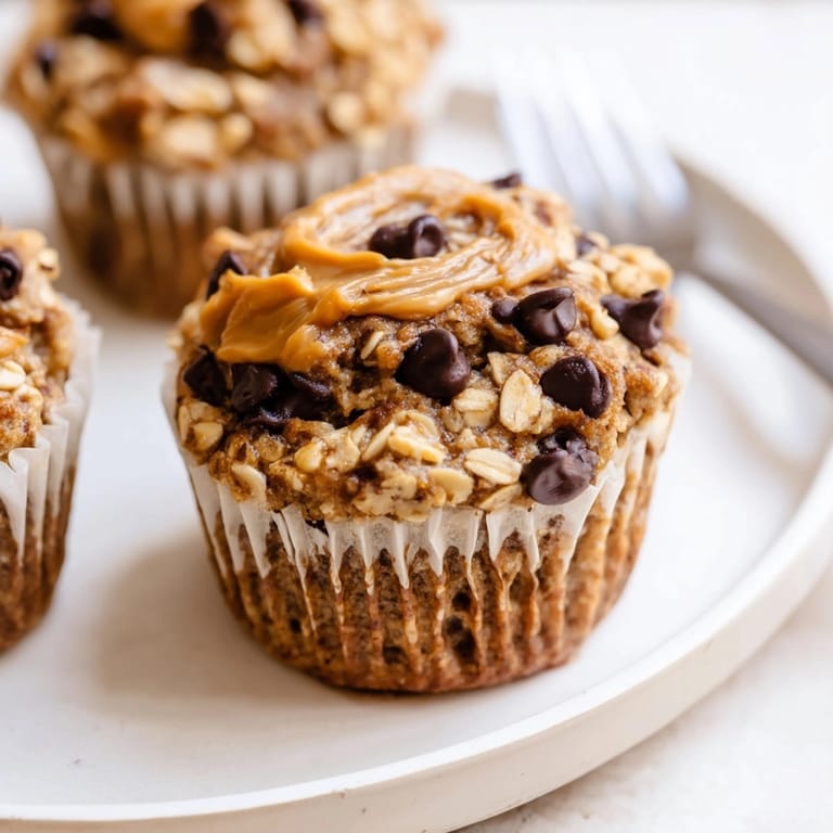 Easy homemade Peanut Butter Banana Oat Muffins with oats, nuts on top, for breakfast.