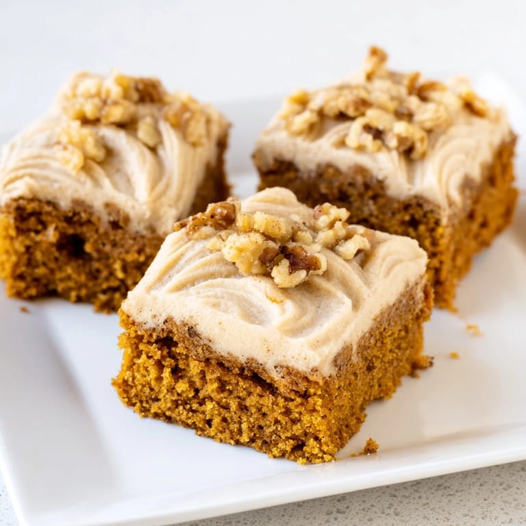 Deliciously frosted Pumpkin Bars with a warmly spiced aroma; a perfect sweet treat for autumn.