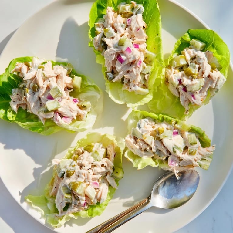 Spoonful of creamy dill pickle chicken salad on butter lettuce, served chilled for best flavor.